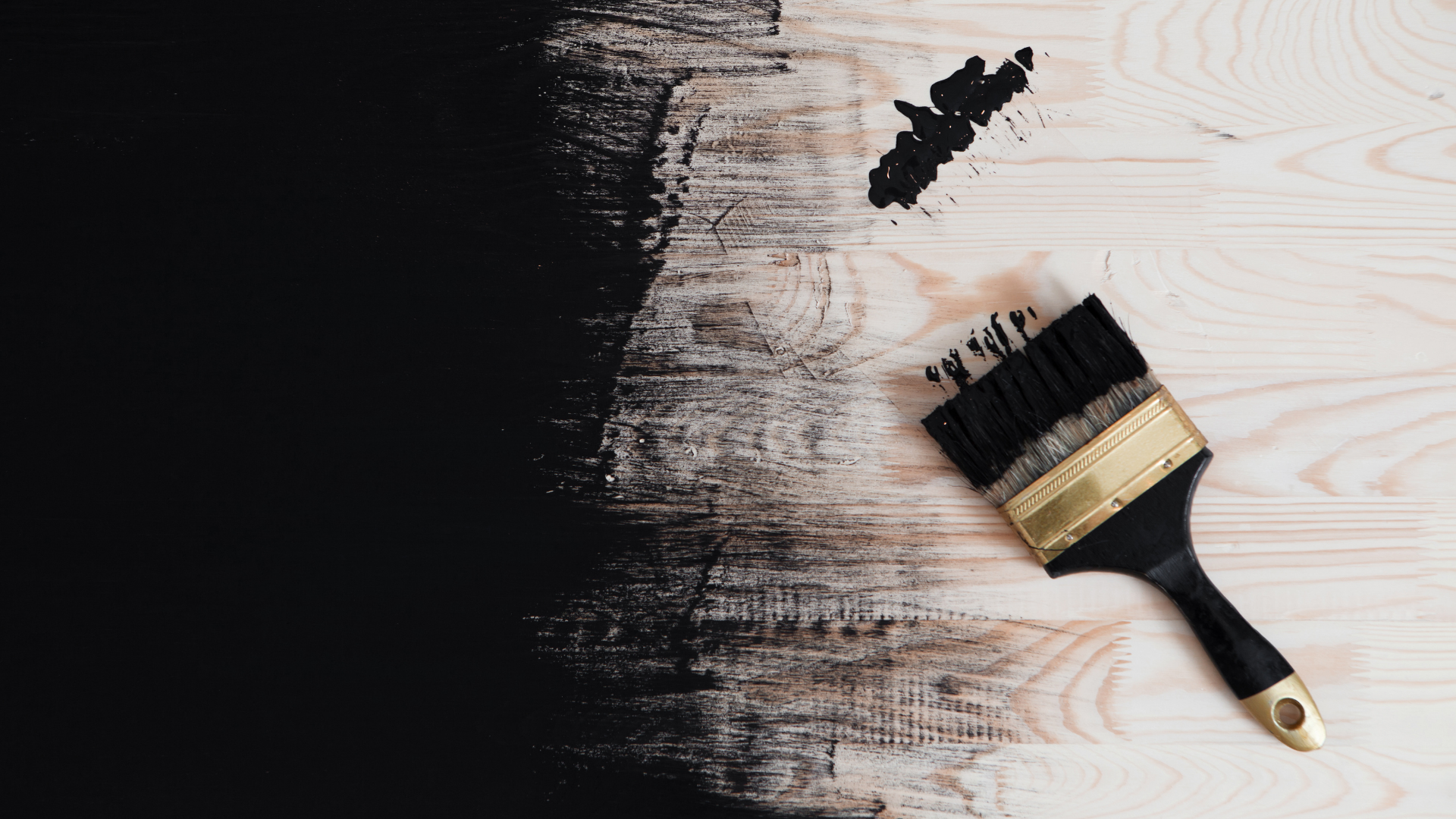 black paint and black paintbrush on wooden boards